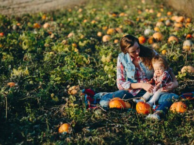 mother and daughter on a field with pumpkins, Halloween eve
